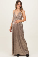 woman wearing a metallic gold halter maternity gown with a deep v-neck and a visible baby bump