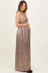 woman wearing a shimmery bronze maternity gown and holding her baby bump