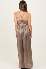 woman wearing a shiny gold maternity maxi dress with crisscross back and adjustable straps