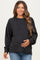 woman wearing a dark gray oversized maternity sweater and holding her baby bump