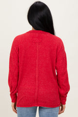 woman wearing a red long sleeve sweater with a relaxed fit and back seam detail, view from the back