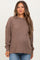 woman wearing a brown ribbed maternity sweater and showing her baby bump