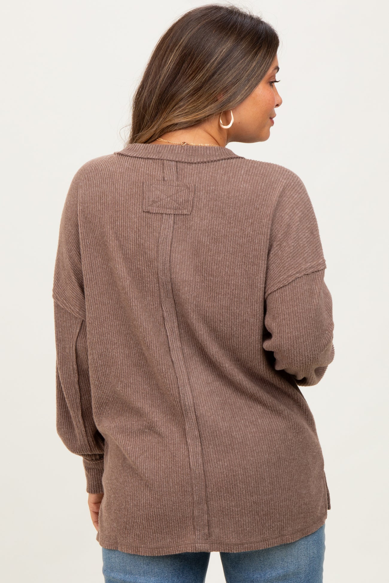 woman wearing a brown ribbed maternity top with a relaxed fit and back seam details