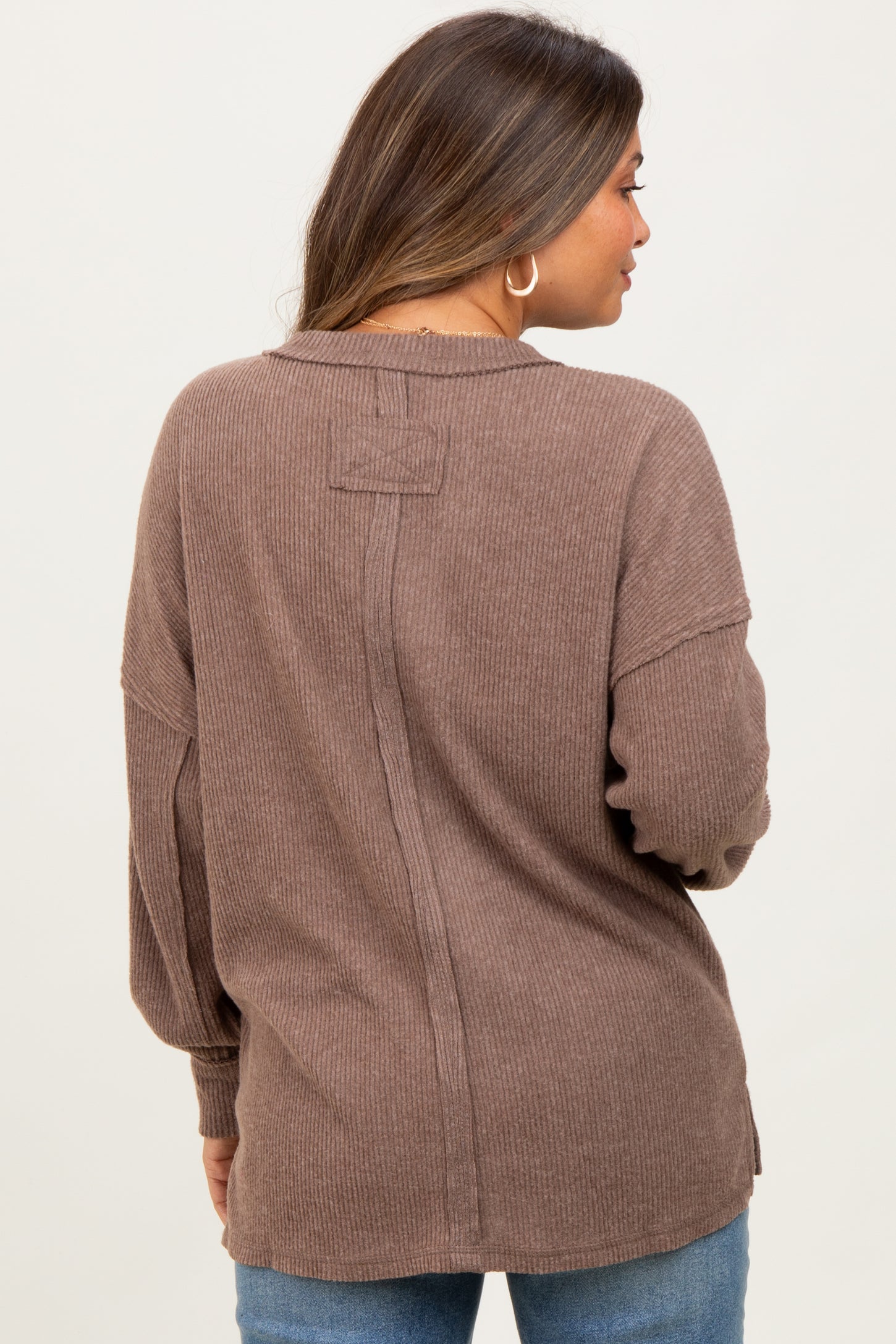 woman wearing a brown ribbed maternity top with a relaxed fit and back seam details