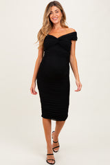 woman wearing a black off-the-shoulder maternity dress with ruching and a visible baby bump