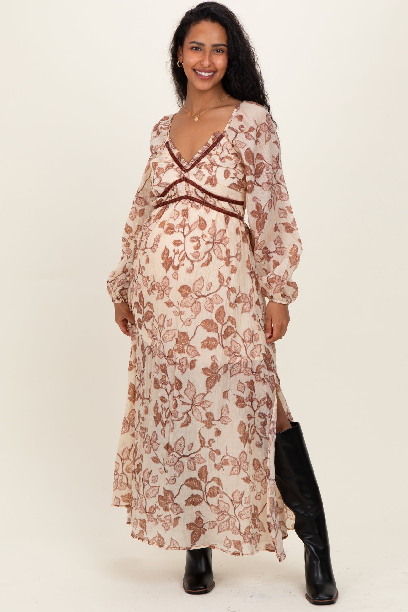 woman wearing a floral long sleeve maternity dress with a v-neckline and side slits, showing her baby bump