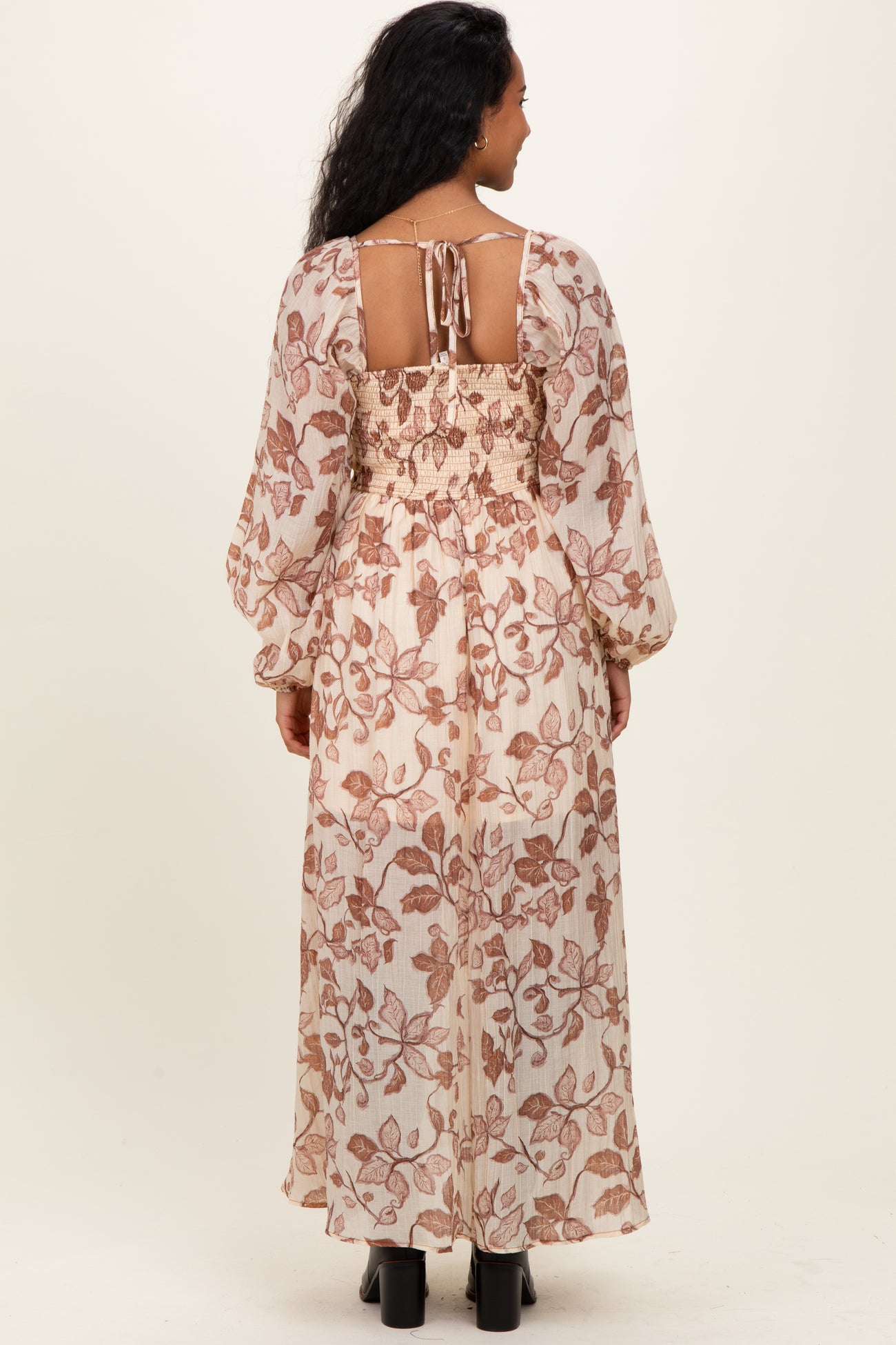 woman wearing a floral printed maternity maxi dress with a smocked back and long sleeves