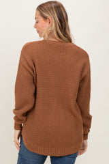 woman wearing a brown chunky knit sweater from the back with relaxed sleeves and a longer hemline
