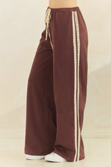woman wearing brown wide-leg pants with lace side details and a drawstring waist