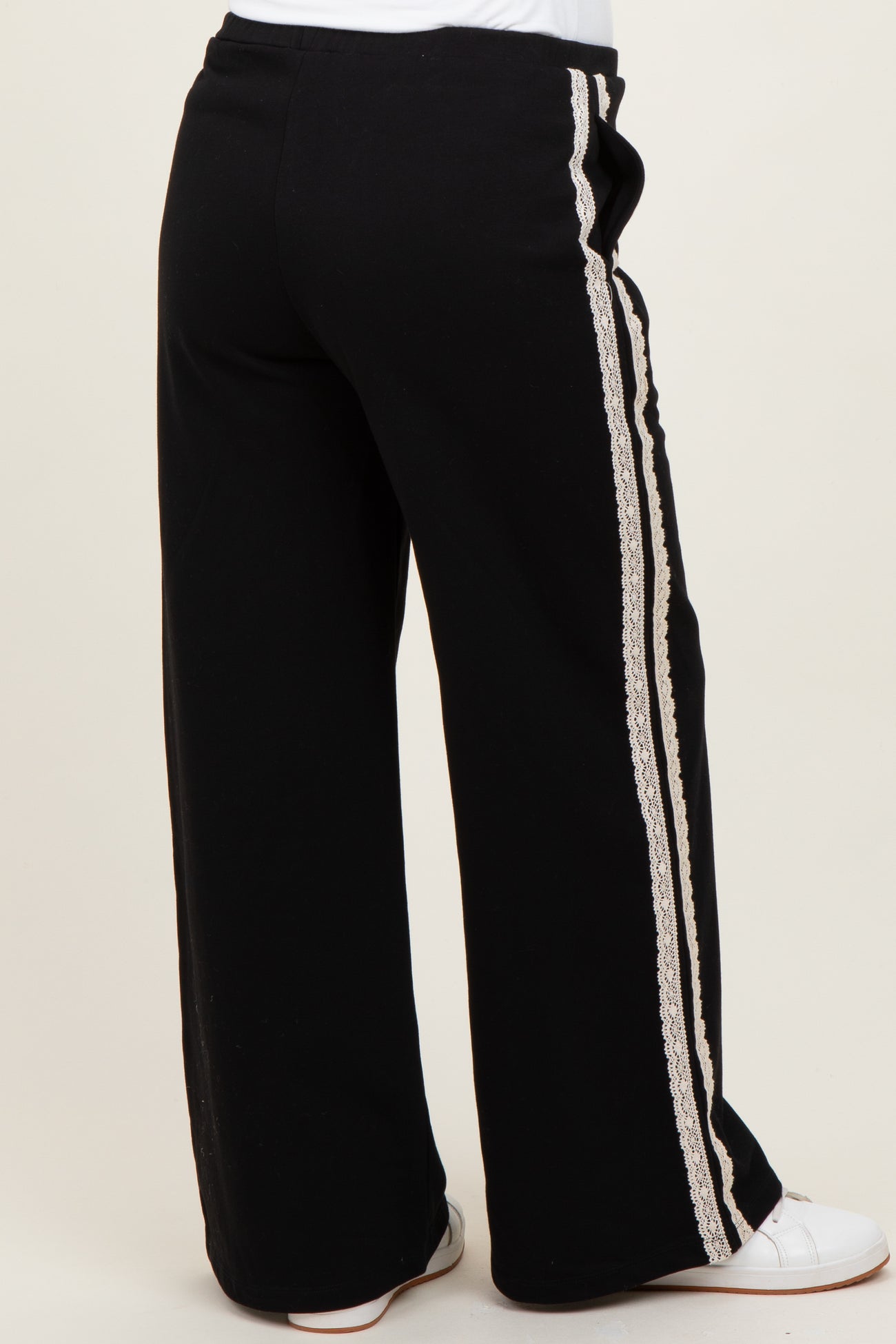 woman wearing black maternity lounge pants with lace side detailing, seen from the back