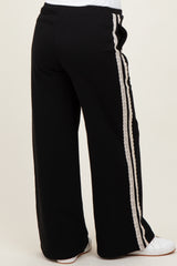 woman wearing black maternity lounge pants with lace side detailing, seen from the back