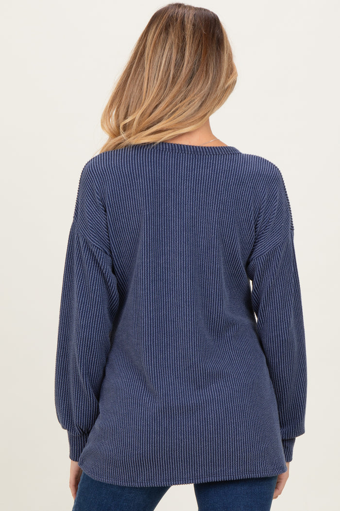 woman wearing a navy blue ribbed maternity sweater with balloon sleeves, showing the back view