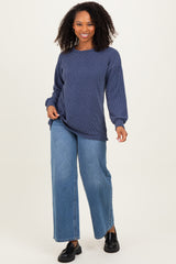 woman wearing a navy striped long sleeve top and blue wide-leg jeans with black shoes