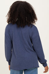 woman wearing a navy blue oversized ribbed long sleeve top, seen from the back with curly hair visible