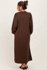 woman wearing a brown maternity maxi dress with balloon sleeves, seen from the back