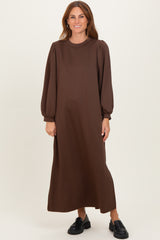 woman wearing a brown long sleeve maxi dress with puff sleeves and a relaxed fit