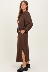 woman wearing a brown long sleeve maxi dress with pockets and side slits, styled casually with black footwear