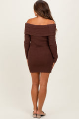 woman wearing a brown off-the-shoulder ribbed maternity dress, showing a fitted silhouette and long sleeves
