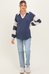 woman wearing a navy and cream striped maternity sweater with a collar and loose fit, showcasing her baby bump