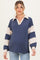 woman wearing a navy and cream striped maternity pullover top with a collared neckline and oversized sleeves, baby bump visible