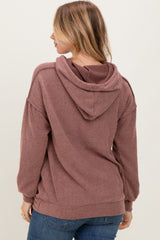 woman wearing a mauve ribbed hoodie with a back hood and dropped shoulders, styled with blue jeans