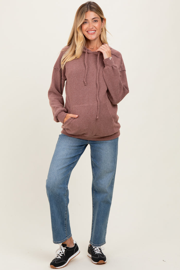 woman wearing a mauve ribbed maternity hooded sweatshirt with a baby bump and blue jeans