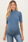 woman wearing a blue ribbed maternity top and showing her baby bump