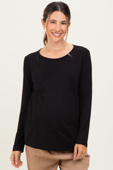 woman wearing a black long sleeve maternity top with gathered detailing and a visible baby bump