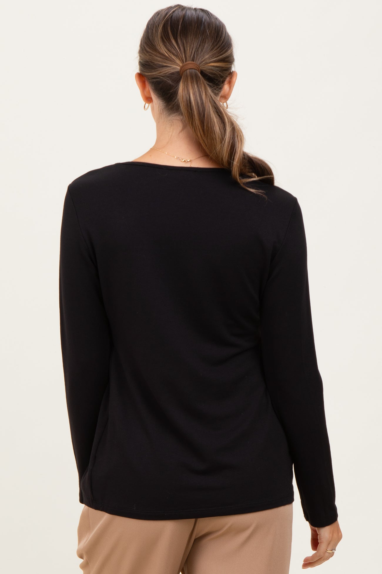 woman wearing a black long sleeve maternity top viewed from the back