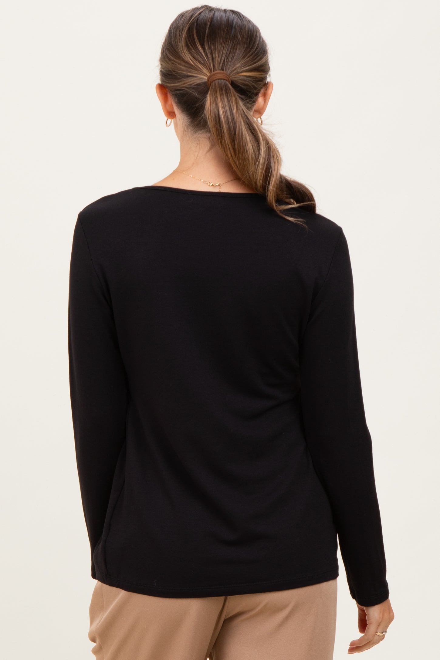 woman wearing a black long sleeve maternity top viewed from the back