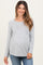 woman wearing a gray long sleeve maternity top with empire waist and visible baby bump