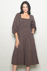 woman wearing a brown checkered midi dress with a square neckline and puff sleeves