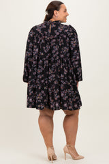 woman wearing a black floral plus size dress with long sleeves and a tiered skirt, shown from the back