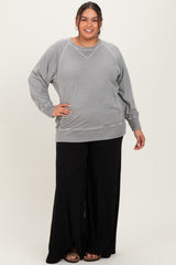 woman wearing a gray oversized sweatshirt with ribbed details and black wide-leg pants