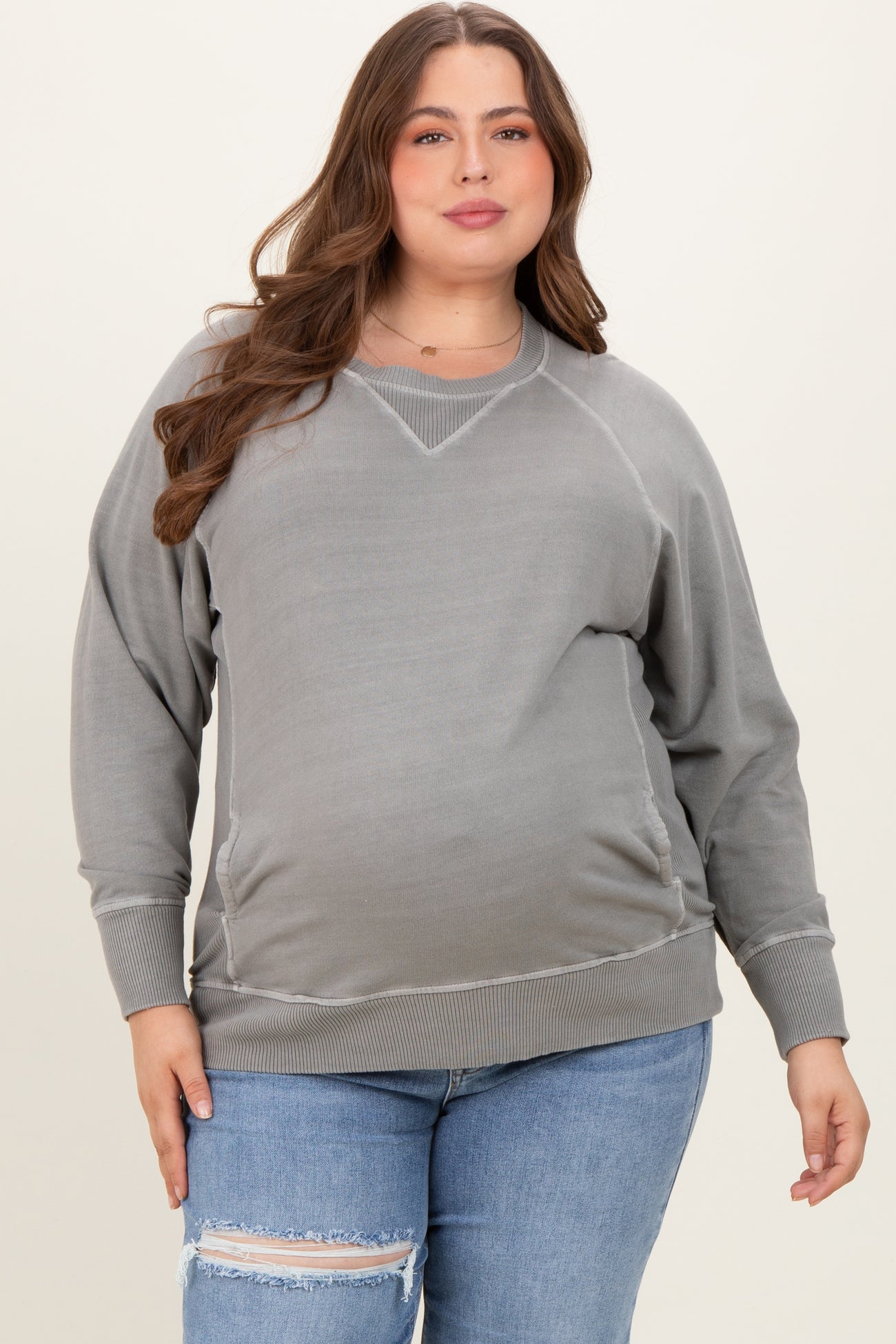 woman wearing a gray oversized maternity sweatshirt with side ruching and a baby bump visible