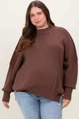 woman wearing a brown oversized ribbed maternity plus sweater with a high neckline and relaxed fit