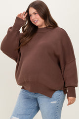 woman wearing a brown oversized maternity sweater with ribbed details and a baby bump visible