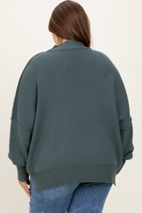 plus size woman wearing an oversized dark green maternity sweater from the back