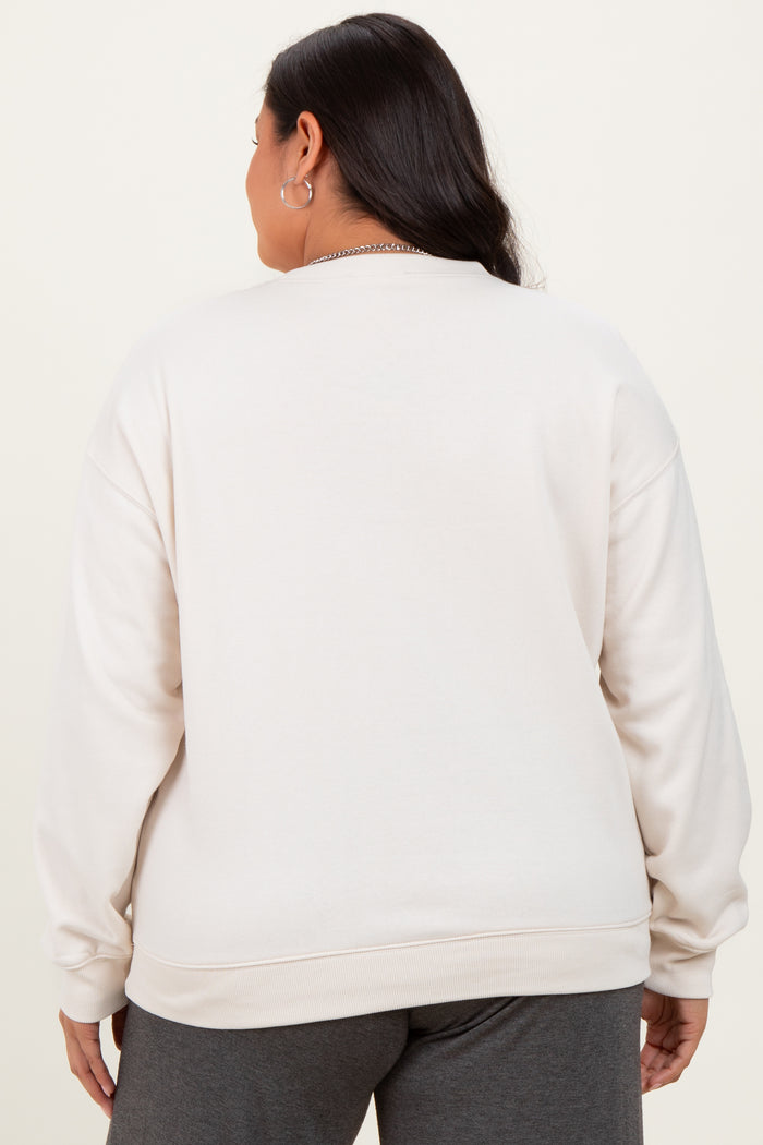 woman wearing a light beige plus size crewneck sweatshirt, seen from the back, with a relaxed fit and long sleeves