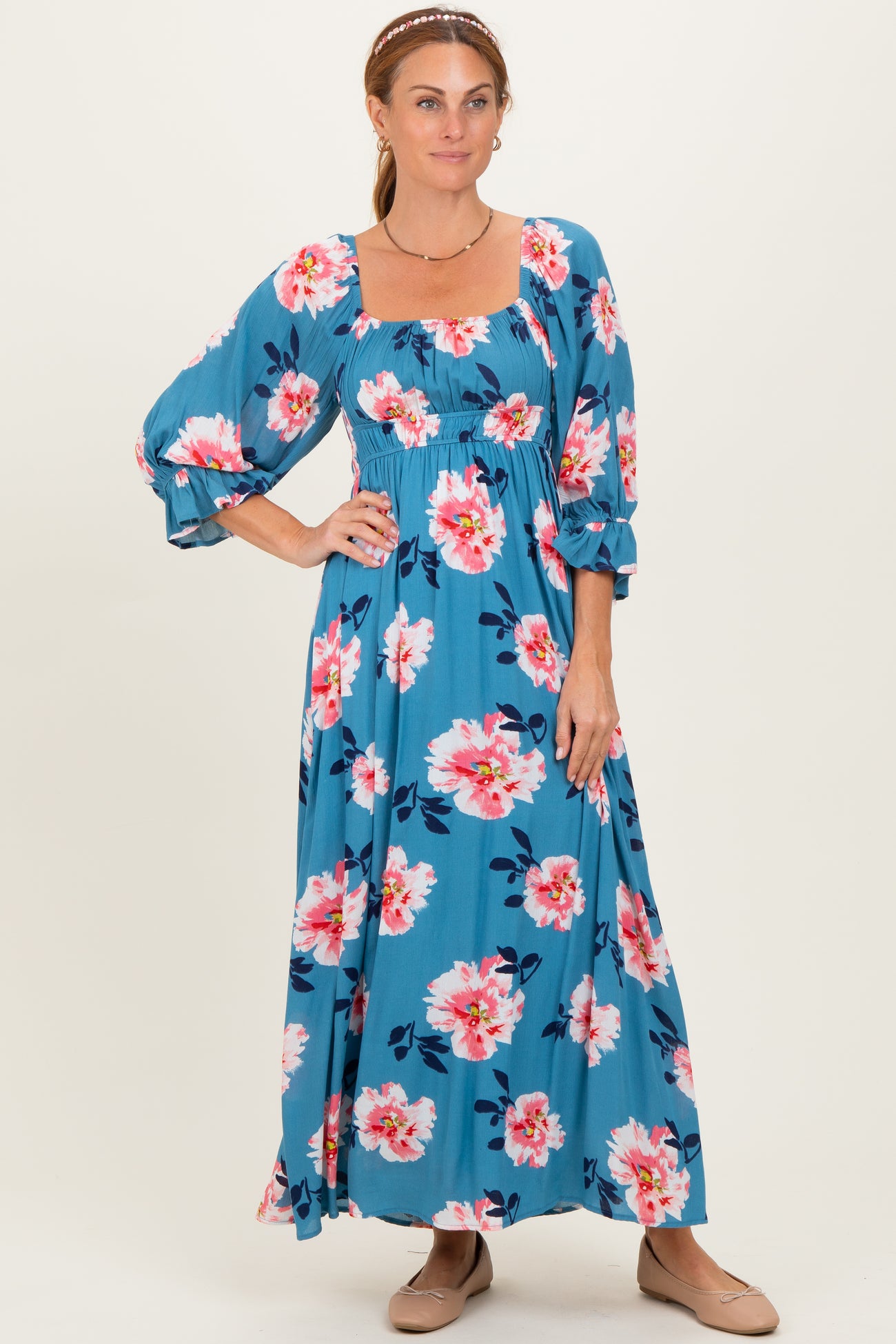 woman wearing a blue floral maxi dress with puff sleeves and a square neckline