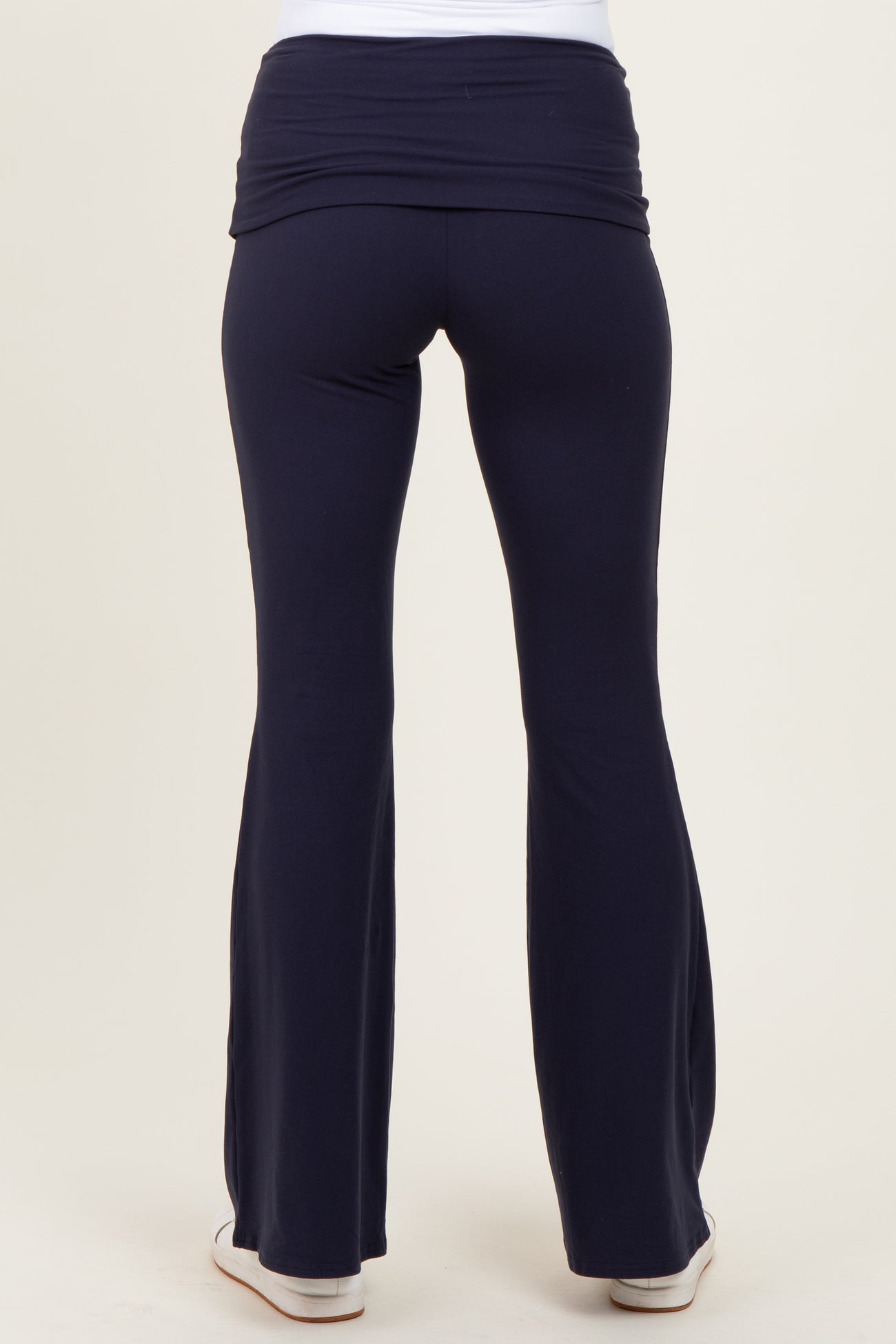 woman wearing navy blue maternity yoga pants with a flattering wide waistband, shown from the back