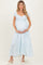woman wearing a light blue maternity dress with short puff sleeves and a tiered skirt, holding her baby bump