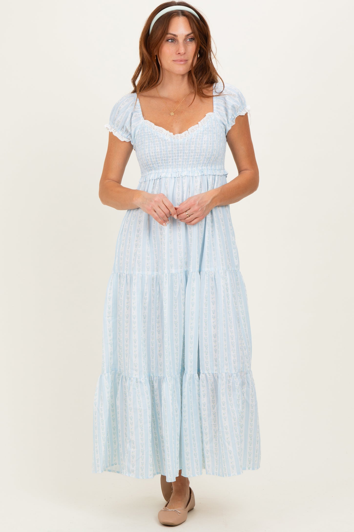 woman wearing a light blue tiered maxi dress with short puff sleeves and a smocked bodice