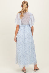 woman wearing a light blue floral maternity maxi dress with flutter sleeves and a cinched waist, showing a baby bump