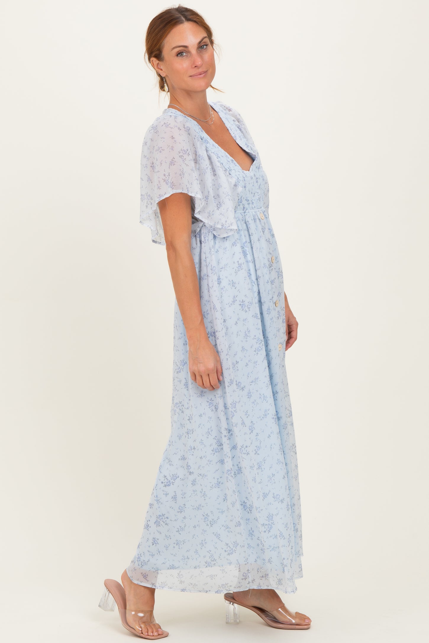 woman wearing a light blue floral maxi dress with short flutter sleeves and a v-neckline