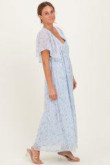 woman wearing a light blue floral maxi dress with short flutter sleeves and a v-neckline