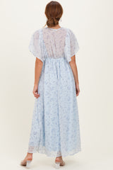 woman wearing a light blue floral maxi dress with short flutter sleeves, viewed from the back