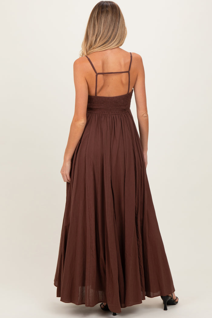 woman wearing a brown maternity maxi dress with spaghetti straps and a smocked back, showing a flowing silhouette