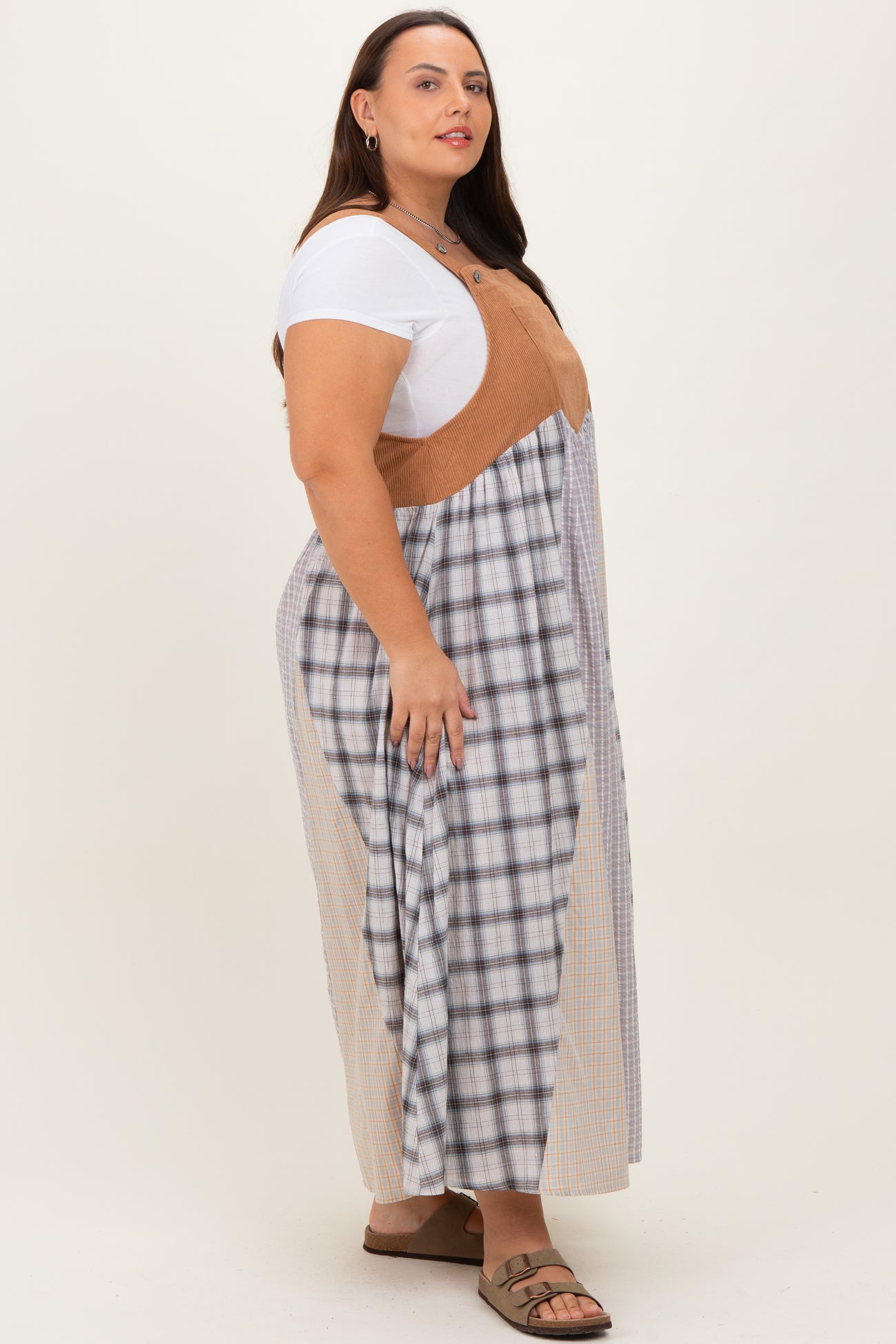 woman wearing a plus size long plaid dress with a tan bodice and side panels, paired with a white t-shirt and sandals