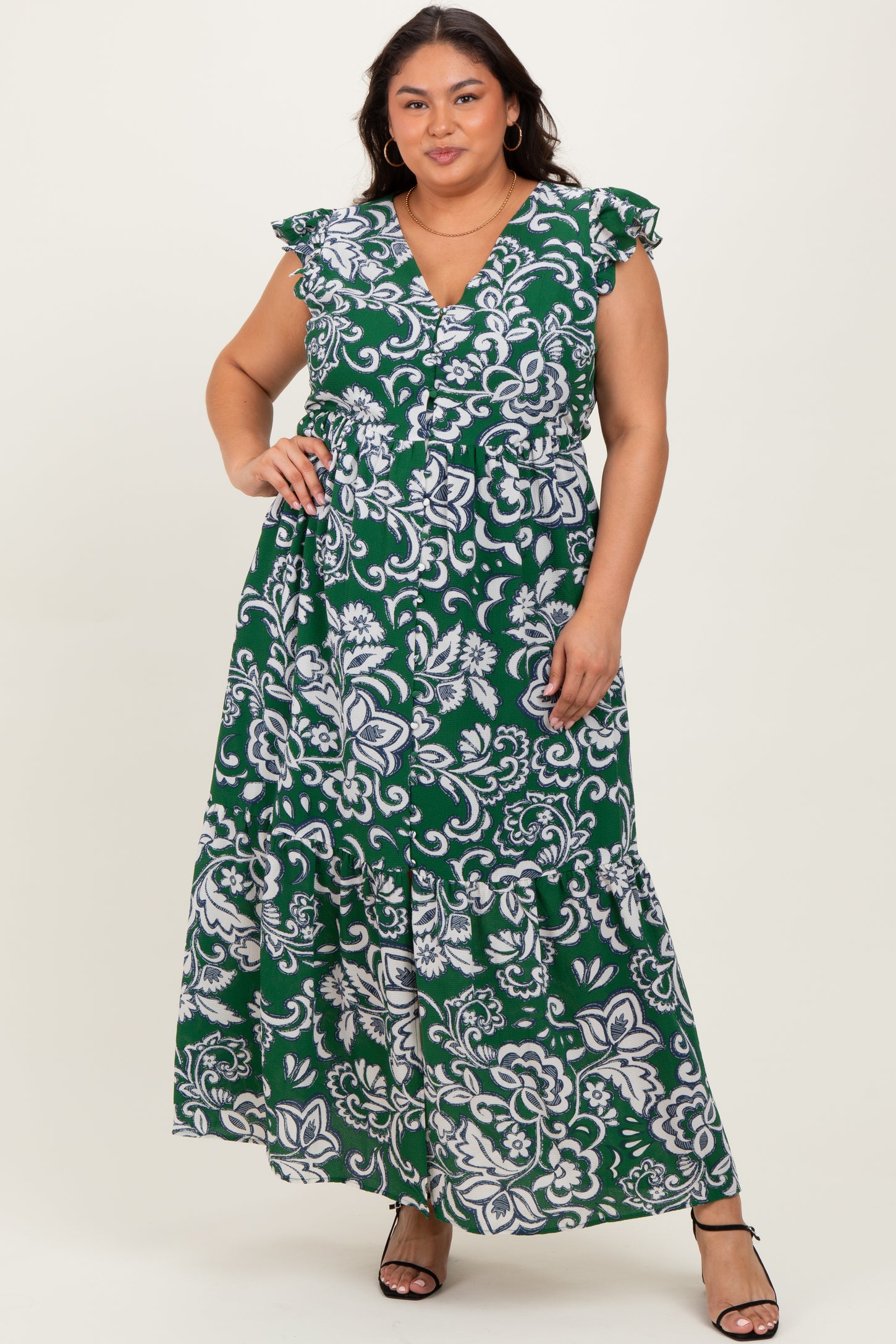 woman wearing a green floral print plus size maxi dress with ruffled sleeves and a deep v-neckline